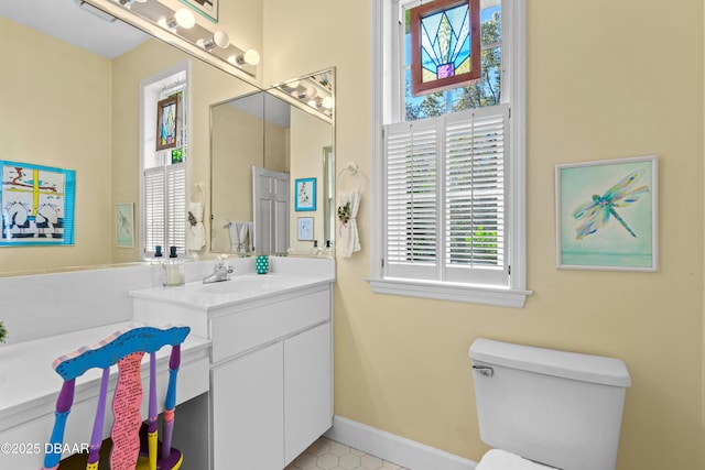 bathroom with vanity, toilet, and baseboards