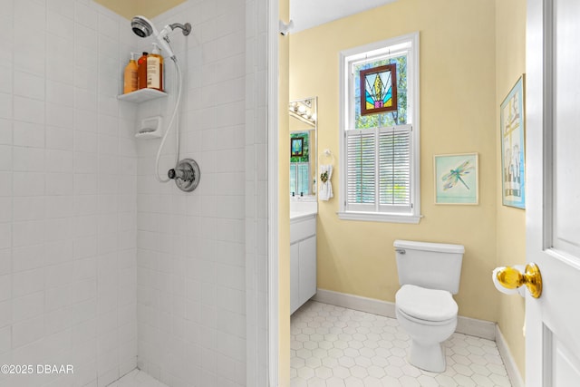 full bathroom featuring tile patterned flooring, baseboards, toilet, a tile shower, and vanity