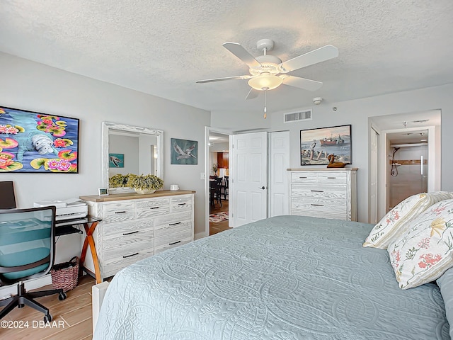 2425 S Atlantic Ave Unit 1004, Daytona Beach Shores, FL 32118 - bedroom featuring wood finished floors, a textured ceiling, and a ceiling fan