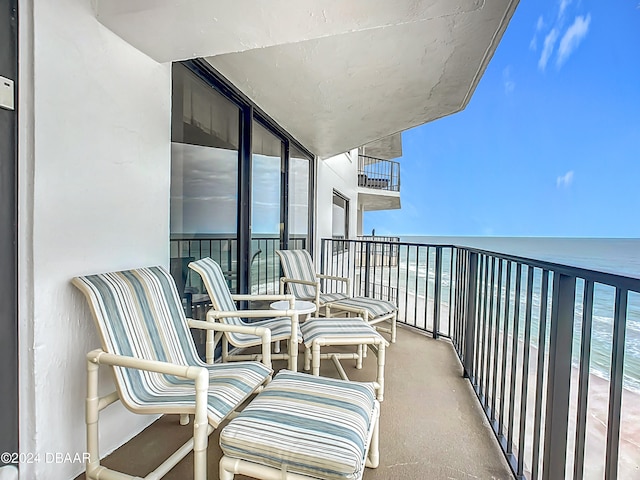 balcony featuring a water view and a beach view