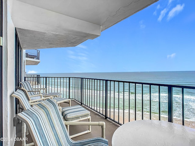 balcony featuring a water view and a view of the beach