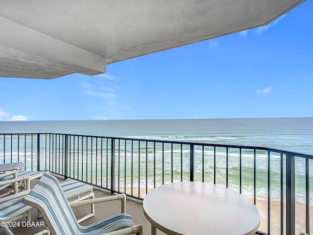 balcony featuring a water view and a view of the beach