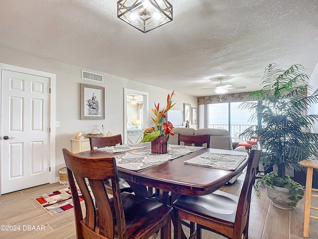 dining area with ceiling fan, light hardwood / wood-style floors, and a textured ceiling