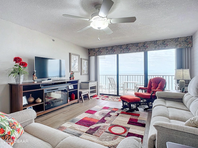 living room featuring hardwood / wood-style floors, a textured ceiling, and ceiling fan