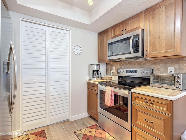 kitchen with backsplash, light hardwood / wood-style flooring, and stainless steel appliances