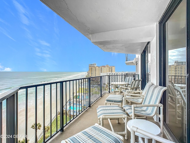 balcony featuring a water view and a beach view