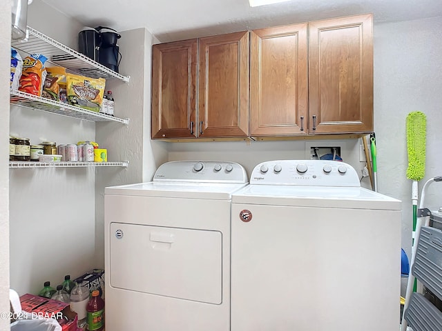 washroom featuring washing machine and clothes dryer and cabinets