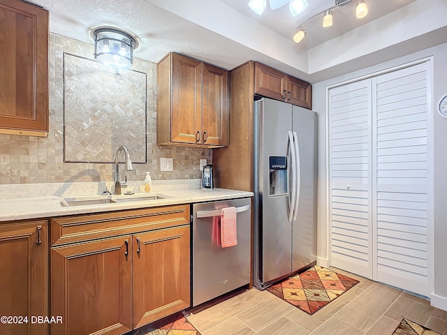 kitchen featuring a textured ceiling, sink, backsplash, and appliances with stainless steel finishes