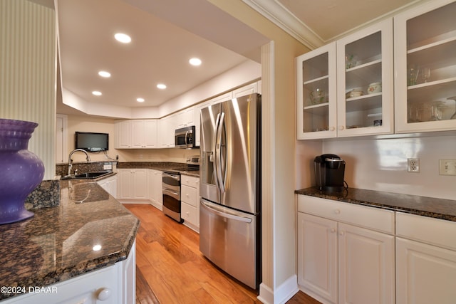4631 S Atlantic Ave Unit 8101, Ponce Inlet, FL 32127 - kitchen featuring appliances with stainless steel finishes, a sink, light wood-style floors, glass insert cabinets, and dark stone countertops