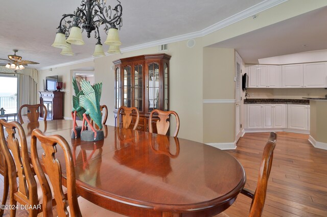 4631 S Atlantic Ave Unit 8101, Ponce Inlet, FL 32127 - dining area featuring light wood-style floors, a ceiling fan, crown molding, baseboards, and a chandelier