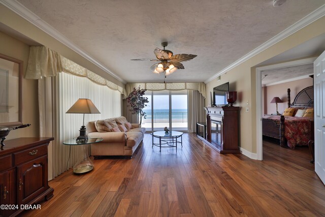 4631 S Atlantic Ave Unit 8101, Ponce Inlet, FL 32127 - living area featuring a ceiling fan, hardwood / wood-style flooring, a fireplace, ornamental molding, and baseboards