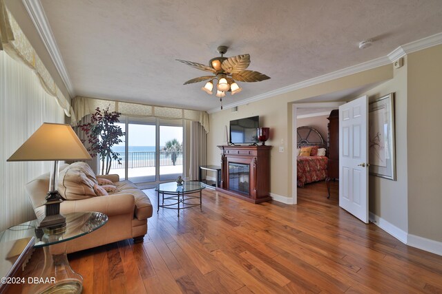 4631 S Atlantic Ave Unit 8101, Ponce Inlet, FL 32127 - living room with a glass covered fireplace, baseboards, wood finished floors, and crown molding