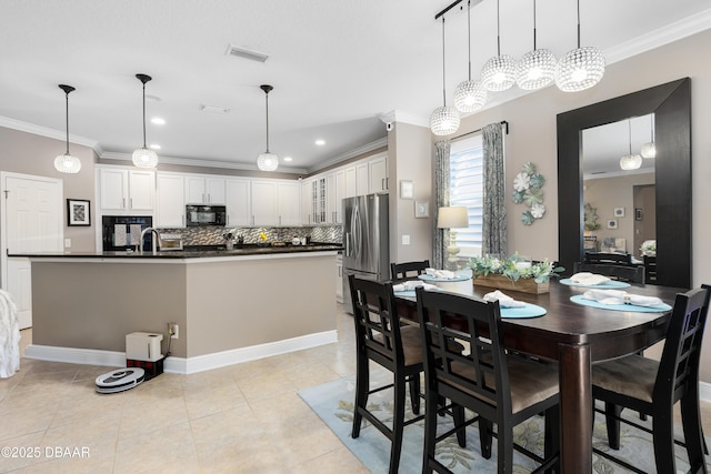 dining room with crown molding, sink, and light tile patterned floors