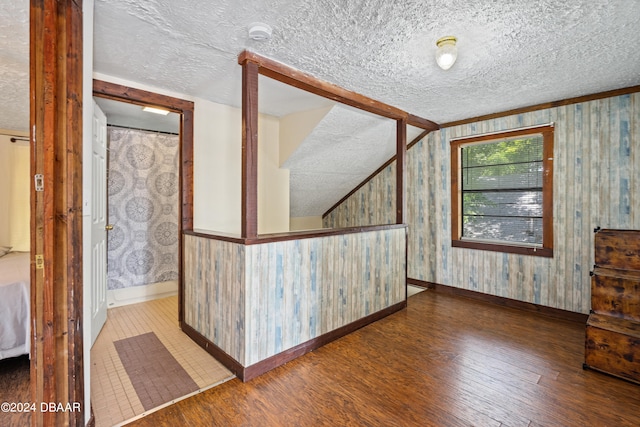 interior space featuring wood walls, wood-type flooring, and a textured ceiling