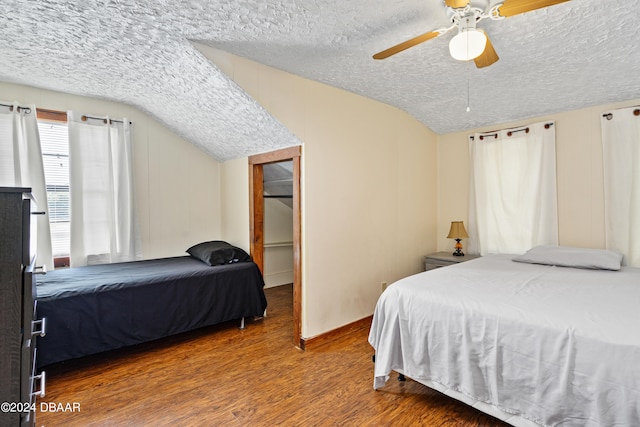 bedroom with ceiling fan, a textured ceiling, hardwood / wood-style flooring, and vaulted ceiling