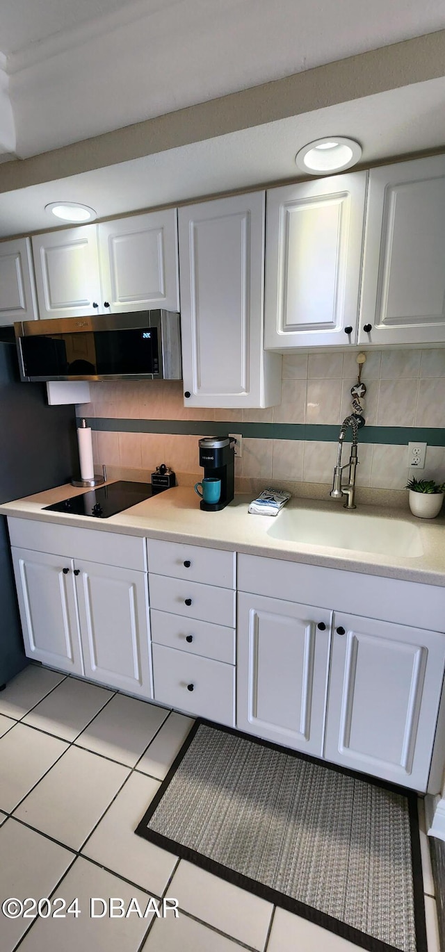 2700 N Atlantic Ave Unit 905, Daytona Beach, FL 32118 - kitchen with black electric cooktop, a sink, extractor fan, and white cabinets