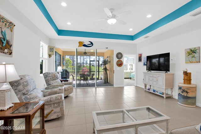 914 Attitude Ave, Daytona Beach, FL 32124 - tiled living room with baseboards, a ceiling fan, visible vents, and a tray ceiling