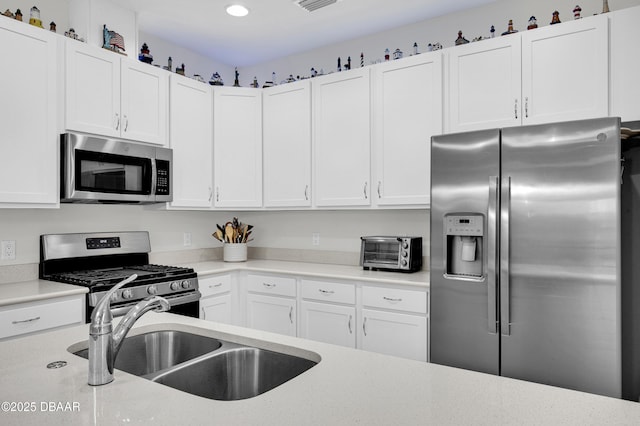 914 Attitude Ave, Daytona Beach, FL 32124 - kitchen featuring appliances with stainless steel finishes, white cabinetry, and a sink
