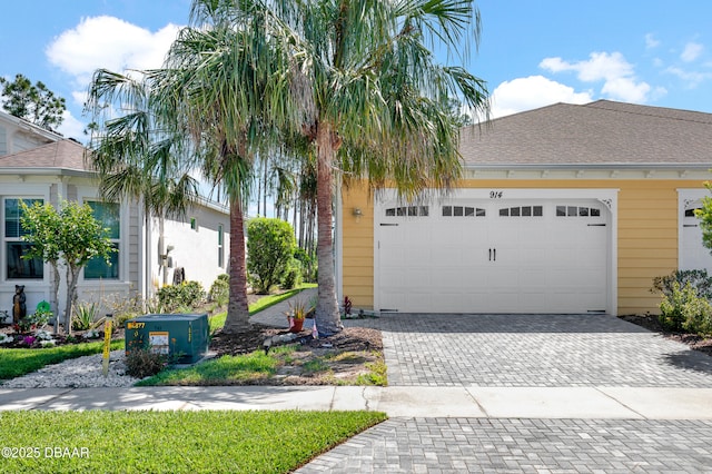 914 Attitude Ave, Daytona Beach, FL 32124 - view of front of house featuring an attached garage, a shingled roof, and decorative driveway