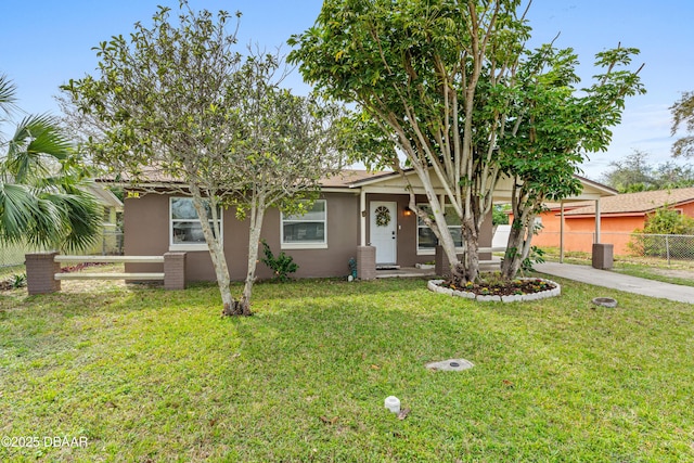 view of front facade with driveway, a front lawn, fence, and stucco siding