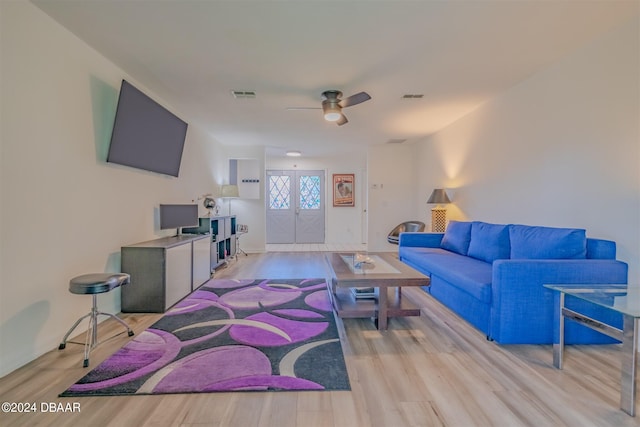 living room featuring light hardwood / wood-style flooring and ceiling fan