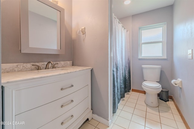 bathroom with toilet, vanity, and tile patterned floors