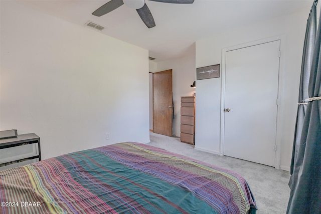 carpeted bedroom featuring ceiling fan and a closet