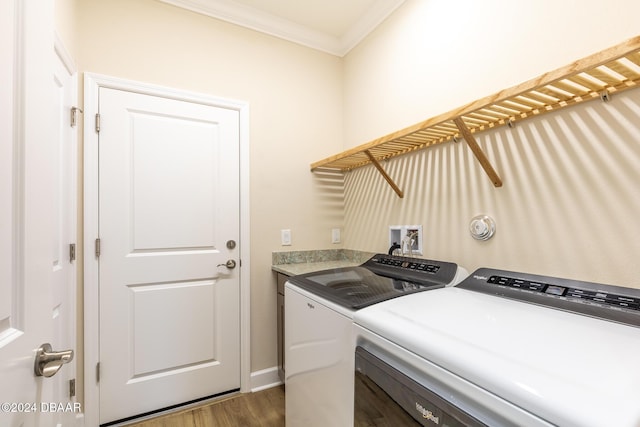 laundry area with dark hardwood / wood-style flooring, washer and clothes dryer, and ornamental molding