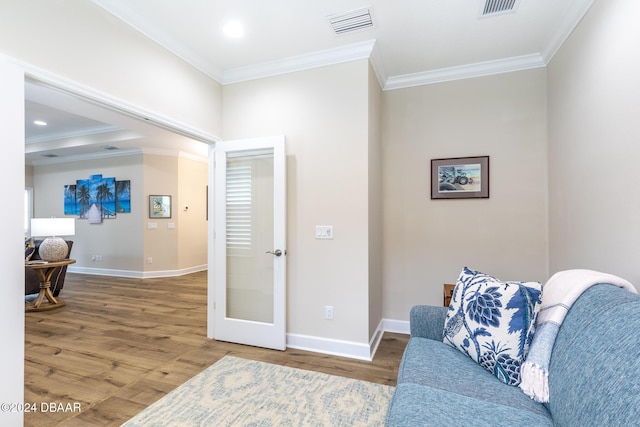 sitting room with hardwood / wood-style floors, french doors, and crown molding