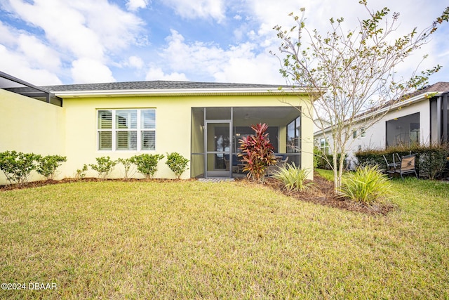 rear view of property with a sunroom and a lawn