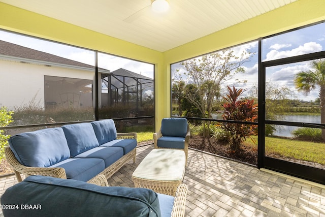 sunroom featuring a water view