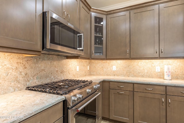 kitchen featuring backsplash, light stone countertops, and stainless steel appliances