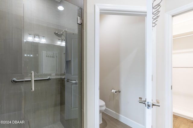 bathroom featuring hardwood / wood-style floors, toilet, and walk in shower