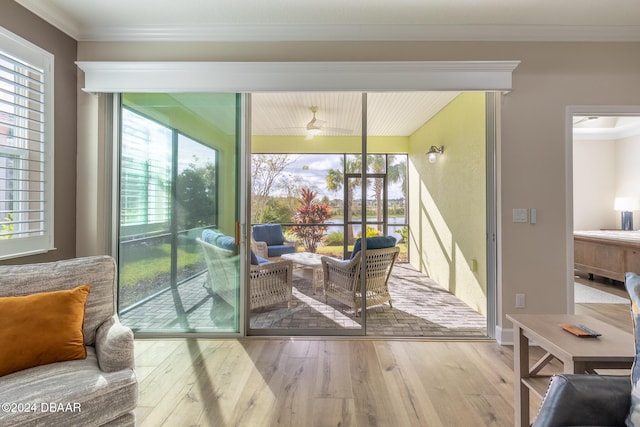 entryway with ceiling fan, wood-type flooring, crown molding, and a wealth of natural light