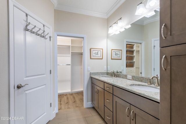 bathroom featuring tile patterned floors, crown molding, and vanity