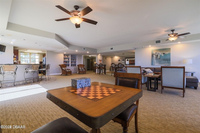 carpeted dining room with ceiling fan