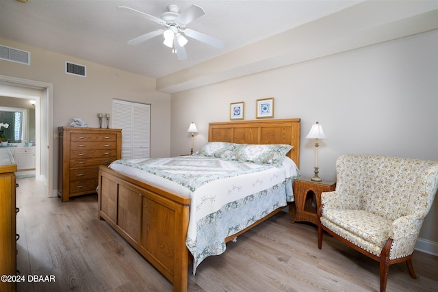 bedroom featuring connected bathroom, a closet, light hardwood / wood-style floors, and ceiling fan