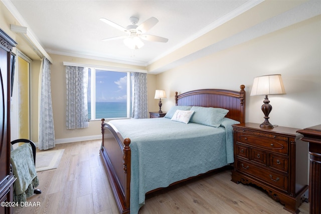 bedroom featuring ceiling fan, a water view, light wood-type flooring, and ornamental molding