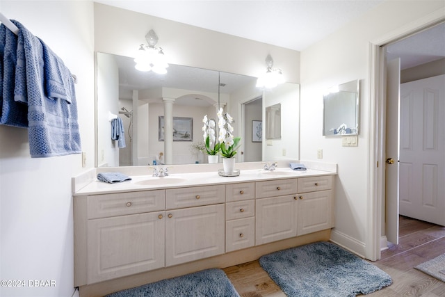 bathroom featuring hardwood / wood-style flooring, ceiling fan, vanity, and ornate columns