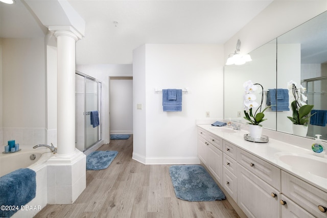 bathroom featuring ornate columns, hardwood / wood-style floors, vanity, and independent shower and bath