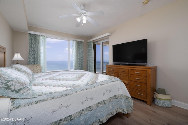 bedroom with access to outside, hardwood / wood-style flooring, and ceiling fan