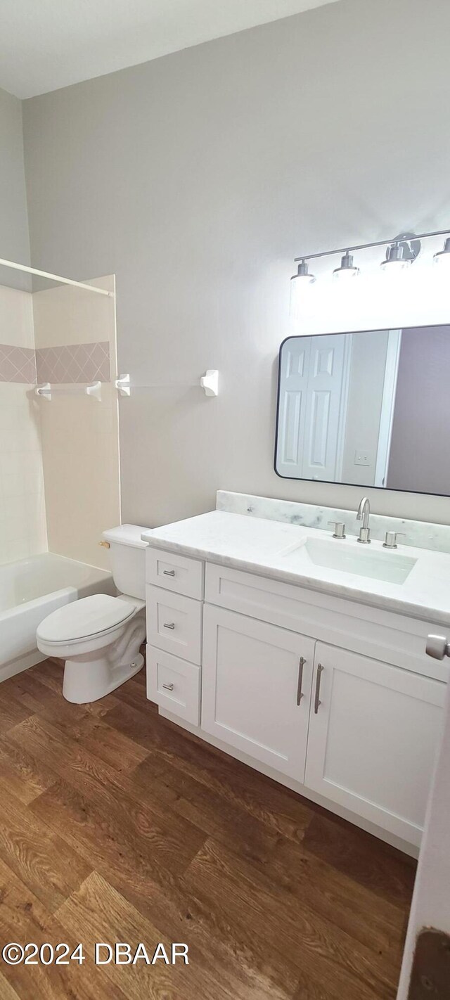 full bathroom with toilet, vanity, and hardwood / wood-style floors