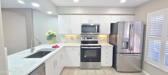 kitchen with white cabinets, sink, tasteful backsplash, light tile patterned flooring, and appliances with stainless steel finishes