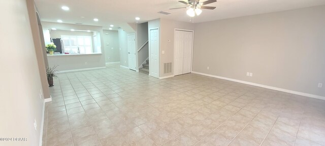 empty room with ceiling fan and light tile patterned floors