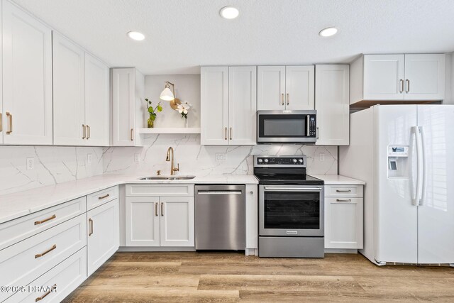 12 Big Buck Trl, Ormond Beach, FL 32174 - kitchen with stainless steel appliances, white cabinetry, open shelves, light wood-type flooring, and recessed lighting