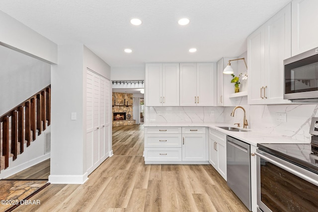 12 Big Buck Trl, Ormond Beach, FL 32174 - kitchen with appliances with stainless steel finishes, light wood-style floors, white cabinetry, tasteful backsplash, and recessed lighting