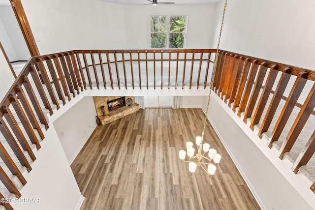 12 Big Buck Trl, Ormond Beach, FL 32174 - stairway with wood finished floors, a stone fireplace, a chandelier, and a ceiling fan