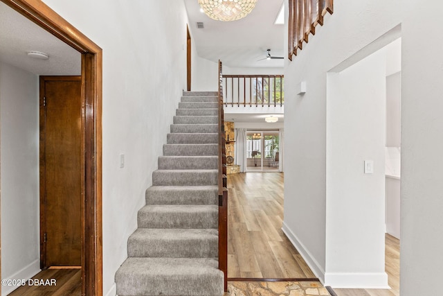12 Big Buck Trl, Ormond Beach, FL 32174 - stairway featuring wood finished floors, a high ceiling, and a ceiling fan