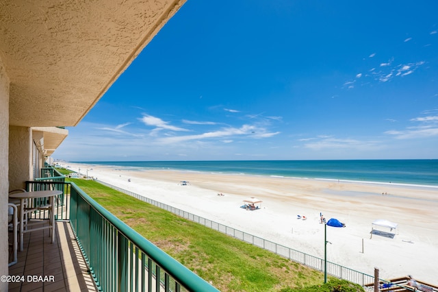 balcony featuring a beach view and a water view