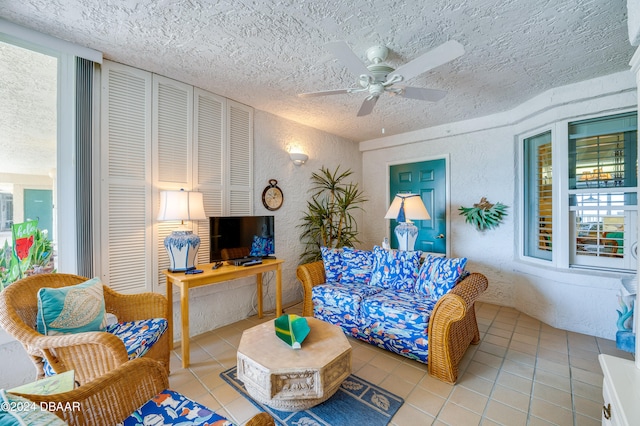 tiled living room featuring a wealth of natural light, a textured ceiling, and ceiling fan